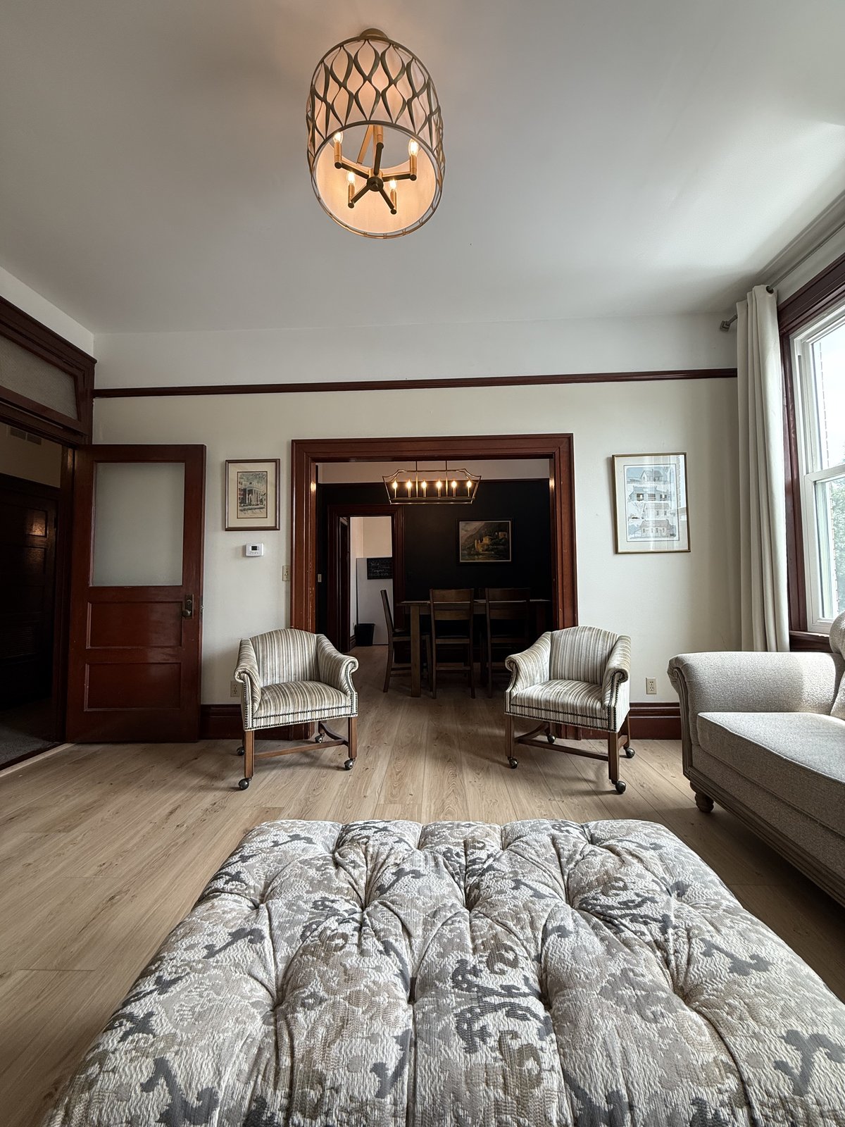 Bedroom 2 — sitting chairs, artwork, original wood trim